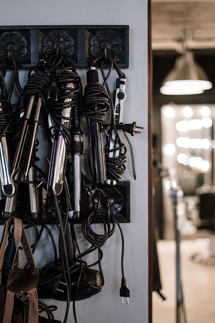 Close-up of hair styling tools hanging in a modern salon setting.