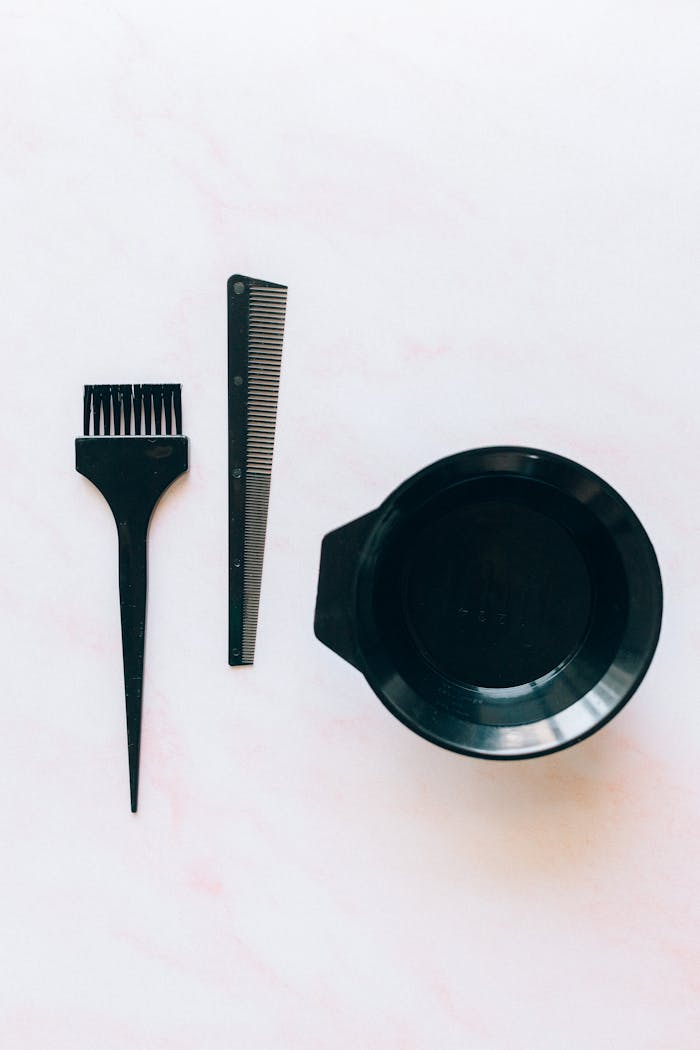 about-01 Set of hairdressing tools for color application, including brush, comb, and bowl.
